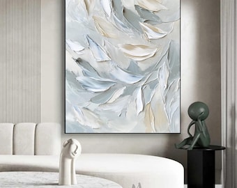 May include: A vertical rectangular canvas painting featuring thick, textured impasto brushstrokes in shades of cream, soft beige, light gray, and pale blue. The abstract composition displays layered, petal-like forms with visible depth and relief.