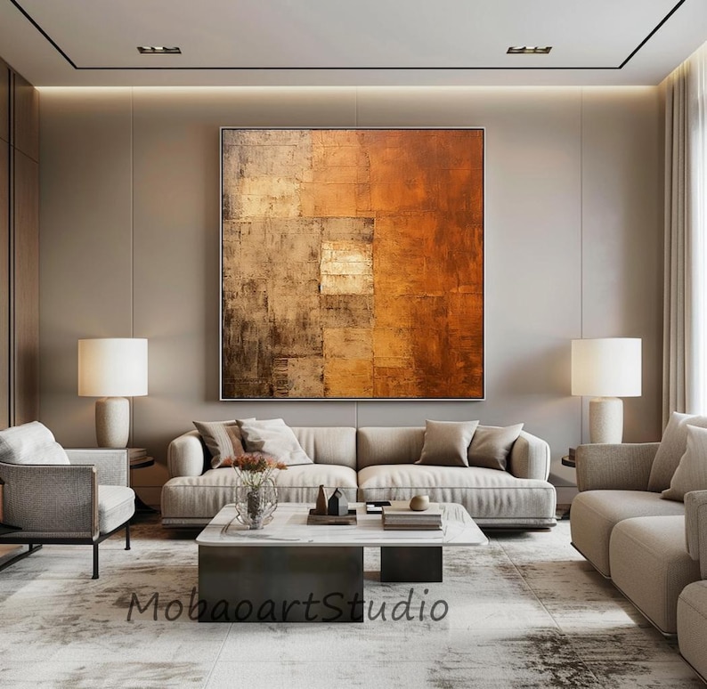 May include: Large abstract painting in a living room setting. The artwork features a textured surface with shades of brown, orange, and beige. The room includes a beige sofa, lamps, and a coffee table. The text "MobaoartStudio" is visible.