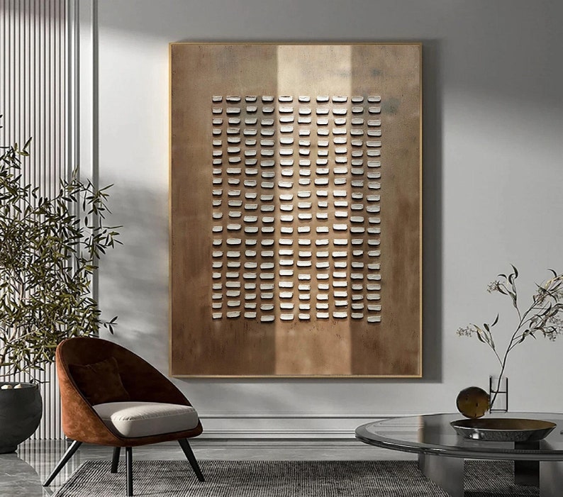 May include: A large abstract painting with a grid pattern of white squares on a brown background. The painting is framed in a thin gold frame.