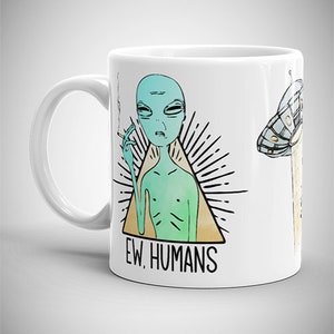 May include: White ceramic mug with a graphic of a green alien smoking a cigarette and the text "EW, HUMANS".