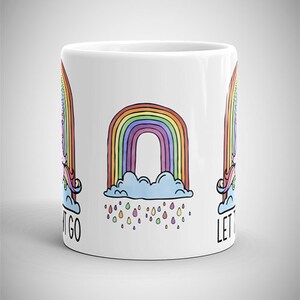 May include: White ceramic mug featuring a colorful rainbow design with a cloud and raindrops. The mug also has a unicorn and the words "LET IT GO" printed on it. The mug is a standard size for coffee or tea.