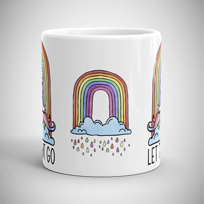 May include: White ceramic mug featuring a colorful rainbow design with a cloud and raindrops. The mug also has a unicorn and the words "LET IT GO" printed on it. The mug is a standard size for coffee or tea.