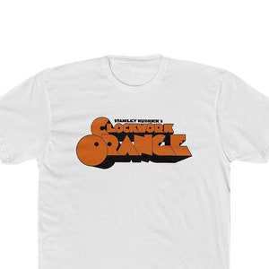 May include: White t-shirt with a black and orange graphic print of the text "Stanley Kubrick's Clockwork Orange".