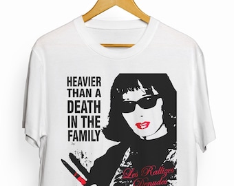 May include: White t-shirt with a black and white graphic of a woman wearing sunglasses and red lipstick. The text "HEAVIER THAN A DEATH IN THE FAMILY" is printed in black above the graphic. The text "Los Rallizes Denudes" is printed in red below the graphic.