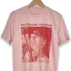May include: Pink t-shirt with a red image of a person's face and the text "my bloody valentine" printed on the front.