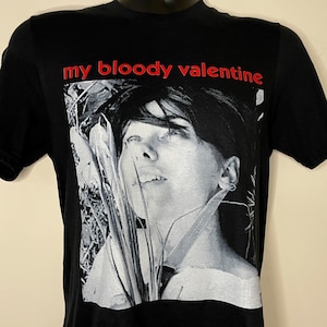 May include: Black t-shirt with a white and gray photo of a woman's face and the text "my bloody valentine" in red.