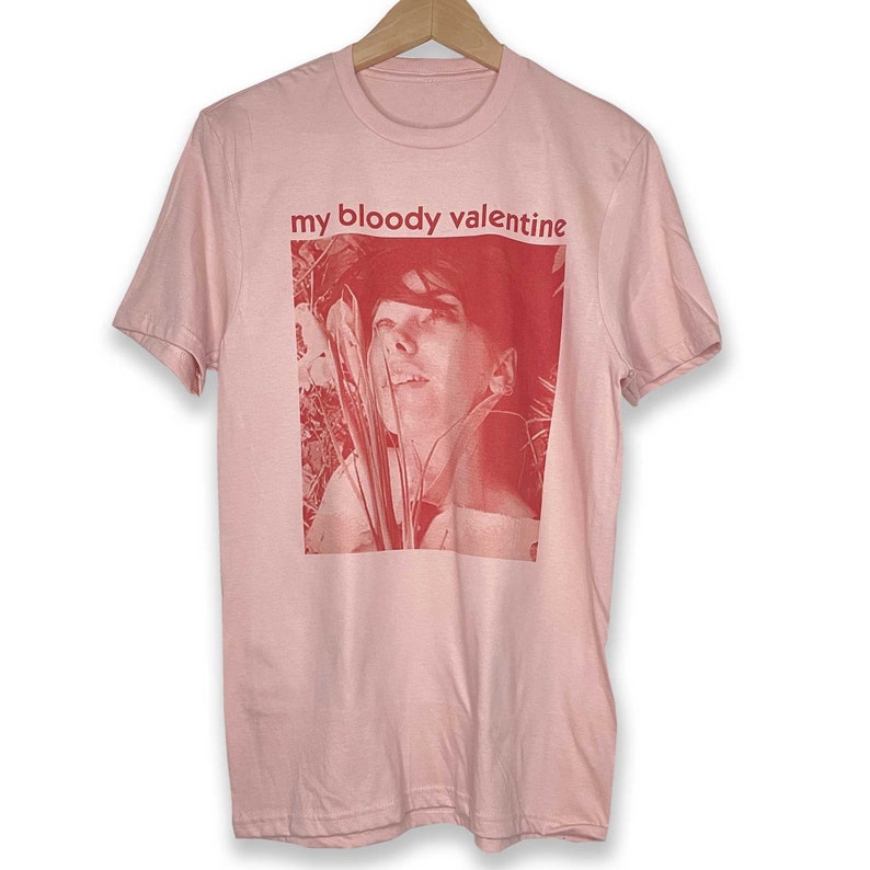 May include: Pink t-shirt with a red image of a person's face and the text "my bloody valentine" printed on the front.