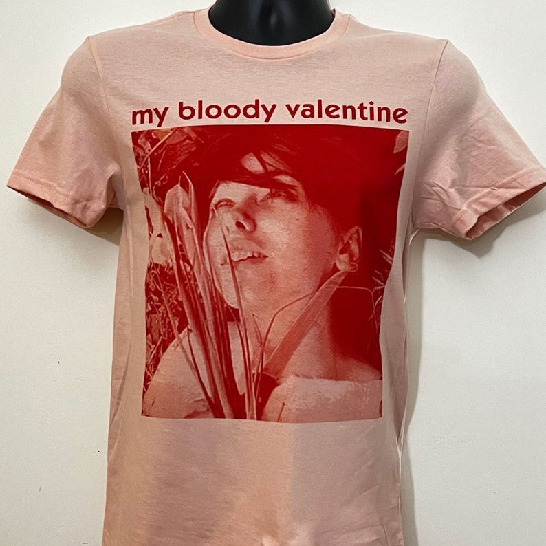 May include: A pink t-shirt with a red image of a woman's face and the text "my bloody valentine" printed on the front.