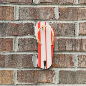 May include: A red and white striped flip flop shaped wall hook with a rope detail.