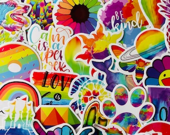 May include: A collection of colorful rainbow stickers with various designs, including a rainbow donut, a turtle, a paw print, a flower, a castle, a hand gesture, a sun, a planet, and the words "Calm is a super power", "Love is", "Be kind", and "Happy".