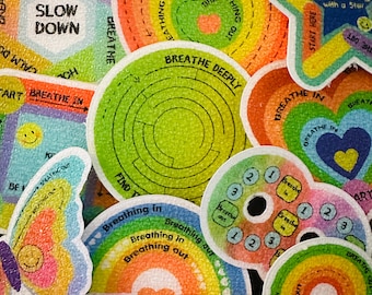 May include: A set of colorful, rainbow-themed stickers with various designs and phrases related to breathing exercises. The stickers feature phrases like "Breathe Deeply", "Slow Down", and "Breathing In/Out".