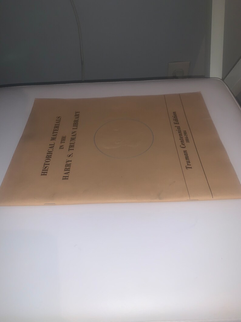 May include: A tan-coloured folder with the text "Historical Materials in the Harry S. Truman Library Truman Centennial Edition 1884-1984" printed on the front.