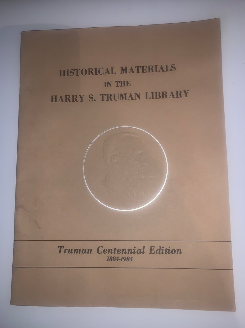 May include: A tan-coloured booklet with the title "Historical Materials in the Harry S. Truman Library" and the text "Truman Centennial Edition 1884-1984". A circular image of Harry S. Truman is in the centre of the booklet.