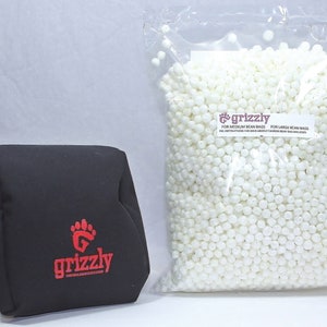 Puede incluir: Una funda de puf negra con un logotipo "grizzly" rojo y una bolsa de bolitas de poliestireno blancas etiquetada "grizzly" para rellenar pufs.
