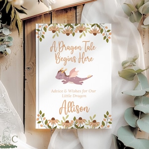 May include: A white book cover with the text "A Dragon Tale Begins Here" and a purple dragon illustration. The book is decorated with floral accents and the name "Allison".