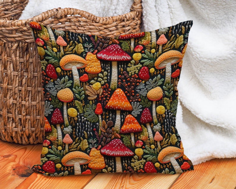 Faux embroidered mushroom pillow covers. Mushrooms are red, orange, and yellow on a black background. They are surrounded by ferns and berries.
