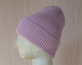 Könnte beinhalten: Eine rosa gestrickte Mütze mit gerippter Struktur.