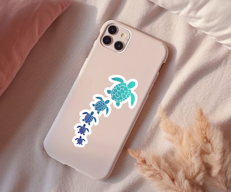 May include: A white phone case with a sticker of a line of blue and green sea turtles. The turtles are different sizes and are arranged in a line from largest to smallest.