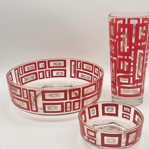 May include: Set of three glass bowls with a geometric pattern in red and gold. The bowls are nested inside each other.
