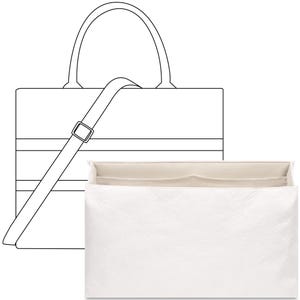 Puede incluir: Una bolsa de mano blanca con una correa negra y un inserto blanco separado con compartimentos. La bolsa de mano tiene un asa negra.