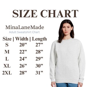 May include: A light grey adult sweatshirt with a size chart. The chart shows measurements for sizes S to 2XL, with widths ranging from 50.8 cm to 71.1 cm and lengths from 68.6 cm to 78.7 cm. The text "MinaLaneMade" is also visible.