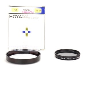 May include: A black Hoya 49mm PL filter for special effects. The filter is in its original packaging, which is white with blue and gold accents. The packaging also includes the text "Hoya Filter for Special Effect".