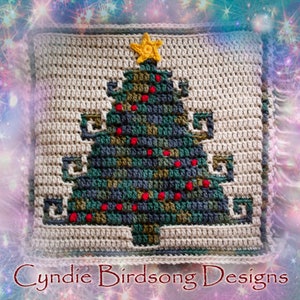 Op de afbeelding: Een gehaakt kerstboomvierkant met een groene, blauwe en bruine boom met rode ornamenten en een gele ster bovenop. De boom staat op een beige achtergrond.