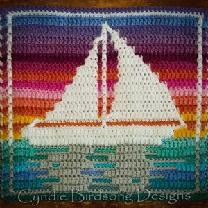 May include: A crocheted square with a white sailboat on a sunset background. The water is represented by blue and green yarn. The square has a fringe border. The text "Cynide Birdsong Designs" is at the bottom of the square.