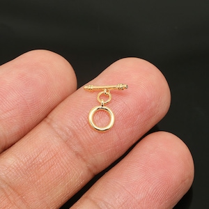 Può includere: Chiusura a scorrimento in metallo dorato con un anello rotondo. La chiusura è progettata per la creazione di gioielli.