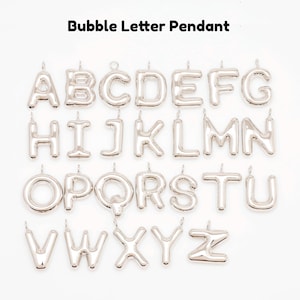 May include: Silver bubble letter pendants, each with a loop for hanging. The letters A through Z are displayed, with the text "Bubble Letter Pendant" above. The pendants have a shiny, metallic finish and are arranged against a white background.