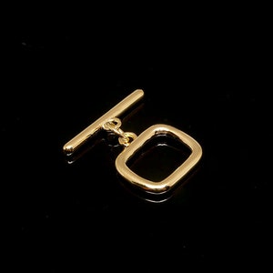 Puede incluir: Cierre de botón de metal dorado con un bucle rectangular. El cierre está diseñado para sujetarse a tela o cuero.