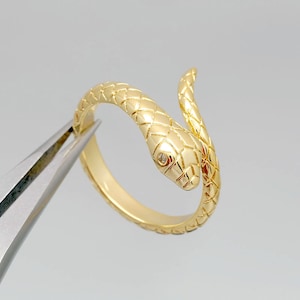 Peut inclure: Une bague en or en forme de serpent avec un petit diamant dans l'œil. Le serpent est enroulé autour de la bande de la bague.