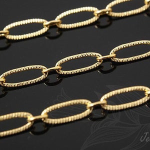 May include: A gold chain with oval links. The links have a textured surface.