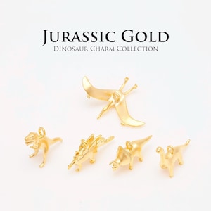 May include: Gold-colored dinosaur charms, including a T-Rex, Stegosaurus, Triceratops, and Pterodactyl. The text "JURASSIC GOLD Dinosaur Charm Collection" is displayed above the charms.