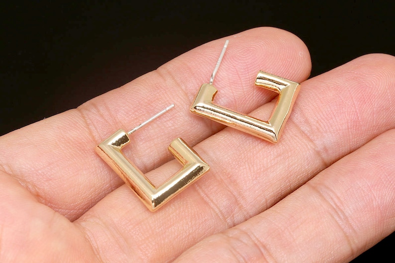 Puede incluir: Un par de pendientes de aro cuadrados de oro. Los pendientes son simples y modernos, con un dise&ntilde;o elegante y minimalista.