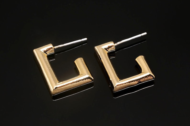 Puede incluir: Un par de pendientes de aro cuadrados de oro con un dise&ntilde;o sencillo. Los pendientes tienen un acabado pulido y est&aacute;n hechos de metal.