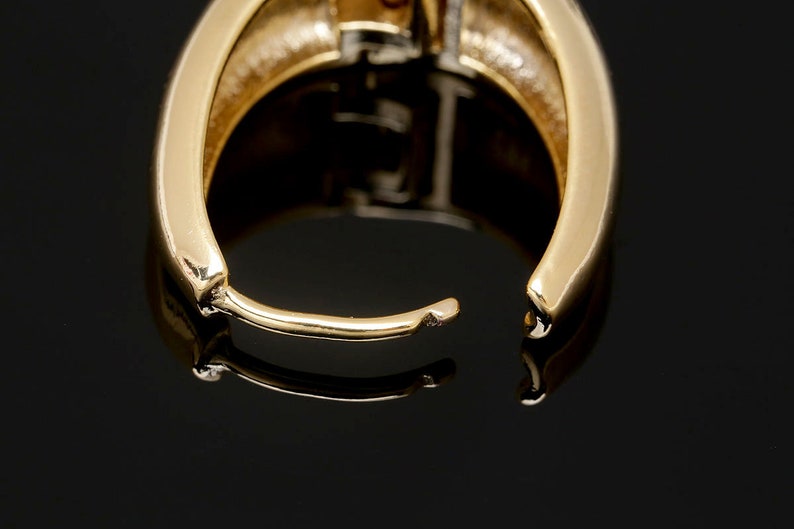 May include: Gold hoop earrings with a smooth, polished finish. The earrings are open and ready to be worn.