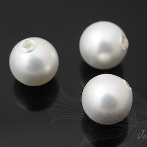 May include: Three white round beads with a hole in the center. The beads are smooth and shiny.