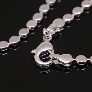 May include: A silver chain necklace with a round link design and a lobster claw clasp.