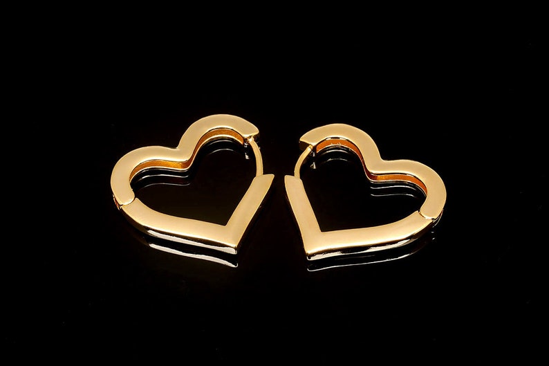 May include: A pair of gold heart-shaped hoop earrings. The earrings are simple and elegant, and would make a great gift for any occasion.