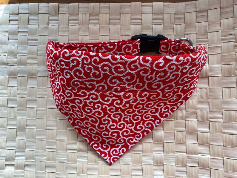 Puede incluir: Collar para perros con estampado rojo y blanco con hebilla de pl&aacute;stico negro y anilla en D de metal plateado. La tela presenta un dise&ntilde;o de remolino repetido. El collar tiene forma triangular, dise&ntilde;ado para usarse como bandana.
