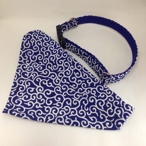 Puede incluir: Juego de collar y pa&ntilde;uelo para perro con estampado azul y blanco. El collar es azul liso con una hebilla plateada. El pa&ntilde;uelo y el collar presentan un dise&ntilde;o blanco en espiral sobre fondo azul.