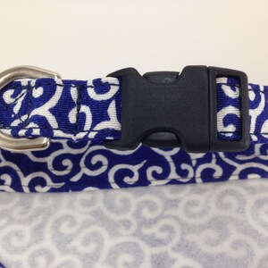 Puede incluir: Collar para perros con un patr&oacute;n de remolinos azules y blancos, una hebilla de pl&aacute;stico negro y una anilla en D de metal plateado. El collar est&aacute; dise&ntilde;ado para mascotas.