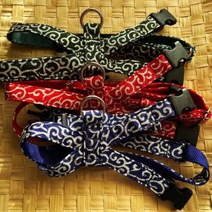 May include: Three dog harnesses in green, red, and blue with a white swirl pattern. The harnesses have a metal ring and a plastic buckle.