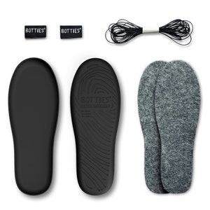 May include: A selection of shoe inserts and accessories. The image shows two black insoles, two small tags with the word "BOTTIES", a bundle of black string, and a pair of grey felt insoles. The insoles are designed for comfort and support.