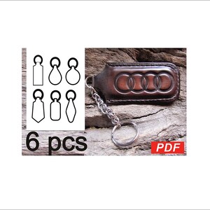 May include: A brown leather keychain with the Audi logo embossed on it. The keychain has a silver chain and key ring. The image also shows six black and white outline shapes and the text "6 pcs".