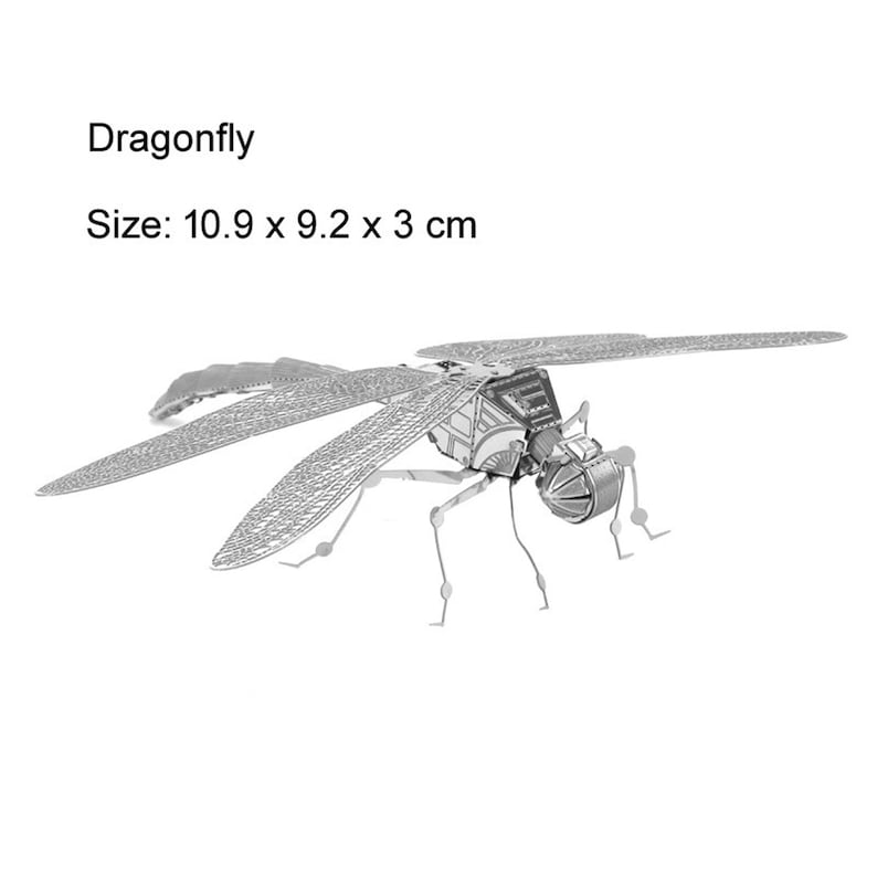 May include: A silver metal dragonfly model with intricate details. The dragonfly is posed with its wings spread out. The model is 10.9 x 9.2 x 3 cm in size.
