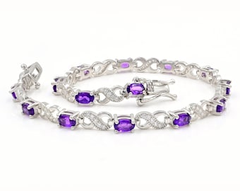 Può includere: Un braccialetto d'argento con un design a infinito presenta pietre di ametista di forma ovale e pietre rotonde trasparenti più piccole.