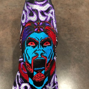 May include: Black leather golf club head cover with an embroidered image of a blue and red face with a purple and white "OLAF" design.