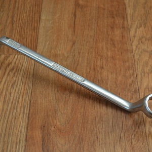 Puede incluir: Una llave inglesa plateada con mango curvo y dos bocas abiertas. La llave está etiquetada con "GOOD TOOLS".